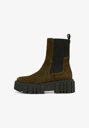 Botte cheville en daim marron avec un panneau latéral élastique noir et une semelle épaisse et robuste. Elle dispose d'une languette à l'arrière pour un enfilage facile.