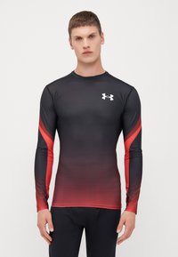 T-shirt de sport à manches longues noir et rouge avec un design dégradé, col rond et accent logo. Confectionné en matériau évacuant l'humidité.