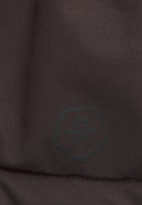 Mörkbrun textilstruktur med en slät yta. Har en subtil präglad logotyp inuti en hexagonal form i det nedre hörnet.