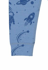 Blått tyg med mörkblå rymdtematiska tryck, inklusive en astronaut, raket, stjärnor och planeter på en ärm.