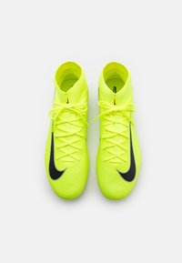 Baskets de sport jaunes vives avec une surface texturée, dotées d'accents noirs et d'un design classique à lacets.