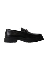 Mocassin noir en cuir avec semelle épaisse et détail décoratif en chaîne métallique sur le dessus, présenté de profil sur fond blanc.