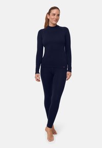 Mörkblå baslager i termiskt material, bestående av en figursydd tröja med långa ärmar och leggings, tillverkade av mjukt tyg med ribbad struktur och minimal märkning.