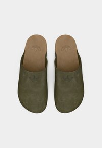 Πράσινα μοκασίνια από σουέτ με στρογγυλεμένη μύτη, υφασμάτινη επιφάνεια και ελαφρύ πάτο από φελλό. Διαθέτουν διακριτικό ανάγλυφο λογότυπο στην επιφάνεια.