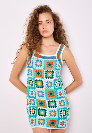 Häkelmini-Kleid mit quadratischem Muster in Türkis, Orange, Grün und Weiß. Quadratischer Ausschnitt mit geflochtenen Akzenten. Weiches, strukturiertes Material.