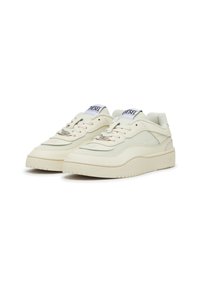 Beige lace-up sneakers with smooth leather and textile upper, padded collar, and textured rubber sole. Features "DIESEL" branding on tongue.