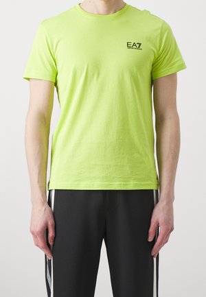 Maglietta in cotone verde neon con scollo rotondo. Presenta un piccolo logo nero sul petto a sinistra e maniche corte. Texture liscia.