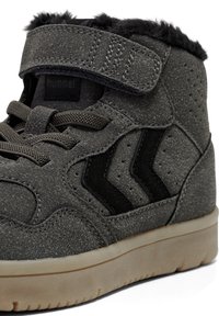 Graue High-Top-Sneaker aus strukturiertem Material, ausgestattet mit einem Klettverschluss, schwarzen Akzenten und einer Gummisohle mit leichtem Profil.