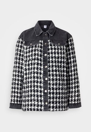 Giacca a scacchi bianco e nero con colletto e maniche in denim. Presenta bottoni a pressione metallici e un design in tessuto testurizzato con tasche.