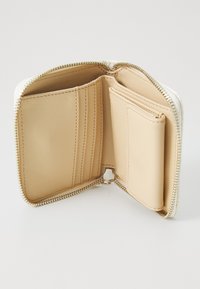 Beige Leder Brieftasche mit goldenem Reißverschluss, ausgestattet mit mehreren Kartenfächern, einem Münzfach und einem glatten, strukturierten Innenfutter.