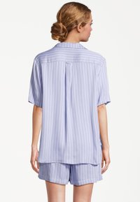 Ljuslila kortärmad pyjamasuppsättning med vertikala vita ränder, featuring en avslappnad passform, mjukt tyg och en plissering bak.