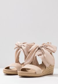 Tělové espadrilky na klínu s velkými béžovými látkovými mašlemi, otevřenou špičkou, polstrovanou semišovou stélkou a opleteným provazovým klínovým podpatkem.