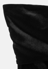 Material din catifea neagră cu o textură moale, având un design drapat. Țesătura pare netedă și are un luciu subtil.