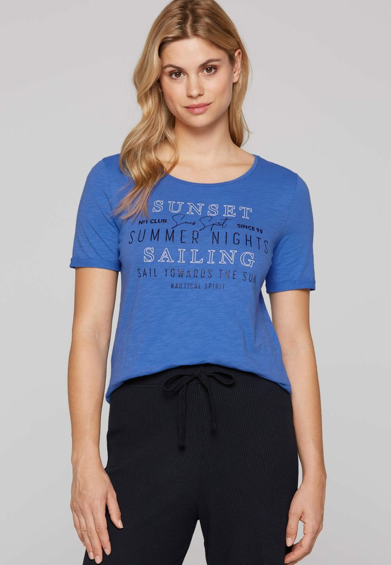 Camiseta de algodón azul con escote redondo y mangas cortas, que presenta un gráfico de texto en blanco sobre navegación en varias tipografías.