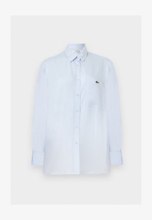 Lichtblauw overhemd met lange mouwen en knopen, met borstzak en klein groen krokodillenlogo op de zak.