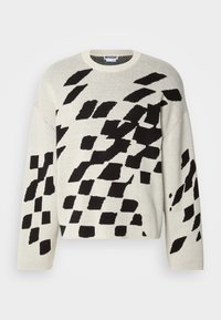 Kremgenser med svarte geometriske mønstre, rund hals, lange ermer og myk strikket tekstur. Løs design som egner seg godt for lag-på-lag.