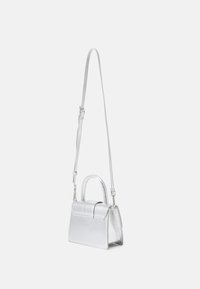 Silver metallic handbag with a structured design, a top handle, and a detachable shoulder strap. Smooth texture and fold-over flap detail.