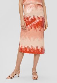 Knee-lange, aansluitende rok met een verlooppatroon van roze naar rode pailletten, voorzien van een zijsplit en een gladde textuur. Draagt met beige sandalen.