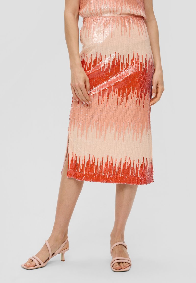 Knee-lange, aansluitende rok met een verlooppatroon van roze naar rode pailletten, voorzien van een zijsplit en een gladde textuur. Draagt met beige sandalen.