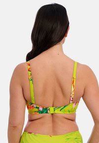 Geel bloemen bikinitop met verstelbare bandjes, voorzien van een kleurrijke tropische print en een sluiting aan de achterkant. Gladde textuur.