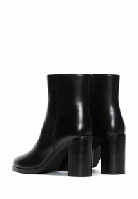 Black leather ankle boots with a smooth finish, featuring a rounded toe and chunky high heel. Simple design, no visible hardware or patterns.
