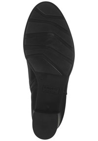 Suela de zapato de goma negra con patrón de textura, marcada con el tamaño 37 y un logotipo. Presenta una forma suave y contorneada para mayor comodidad.