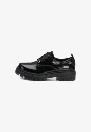 Zapatos de charol negro con punta redondeada, diseño de cordones y suela gruesa y robusta con patrones de relieve prominentes.