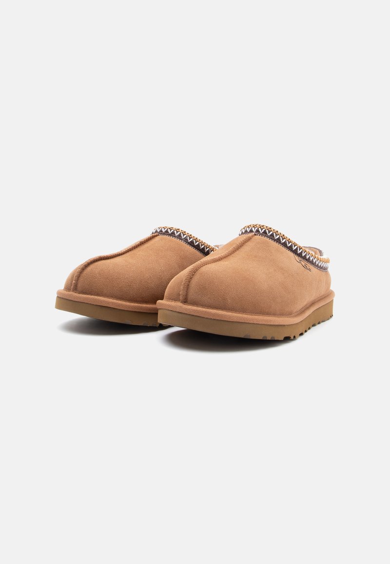 Brune ruskinds slip-on slippers med rund tå, tekstureret kant og en fleksibel gummisål med et mønstrede underside.