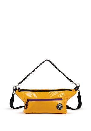 Bolso cruzado acolchado amarillo con un acabado brillante. Cuenta con una correa de trenzado negro, detalles en cremallera morados y un parche de logo redondo.