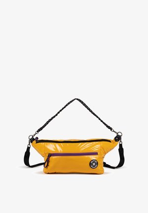 Bolso cruzado acolchado amarillo con un acabado brillante. Cuenta con una correa de trenzado negro, detalles en cremallera morados y un parche de logo redondo.