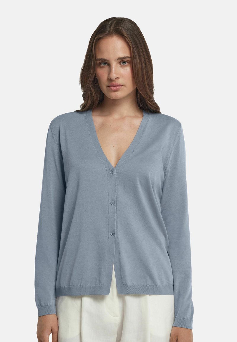 Ljusblå kofta i mjukt material med V-hals, knäppning framtill och långa ärmar. Har en rak nederkant och ribbade ärmslut.