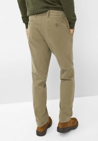 Pantaloni khaki a gamba dritta, realizzati in cotone morbido. Presentano tasche posteriori con chiusura a bottone e una cintura elastica.