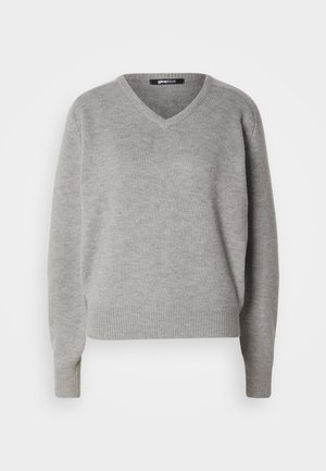 Grå v-hals genser laget av mykt strikket materiale. Har lange ermer og ribbede mansjetter og nederkant. Enkel, klassisk design uten mønstre.