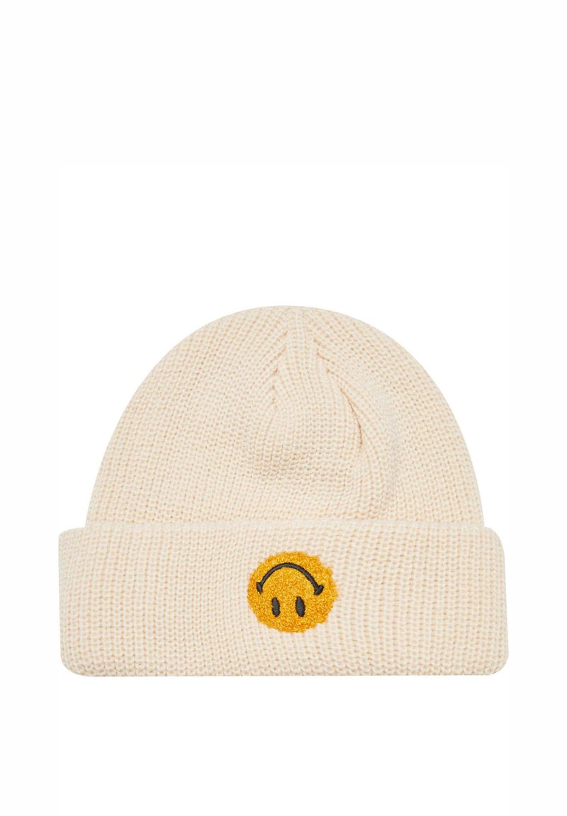 Strikket beanie i blød crème farve med en kant. Har et smiley-ansigt patch i gul med sorte accenter. Tekstureret, varmt stof.