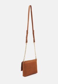 Brun ruskind crossbody taske med en guldkæde-rem, rektangulær form, glat tekstur og en enkel klap-lukning.