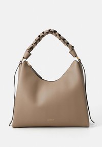 Béžová kožená kabelka s měkkou texturou, zakřiveným tvarem, pleteným uchy a zlatým kováním. Jemné logo značky na přední straně.