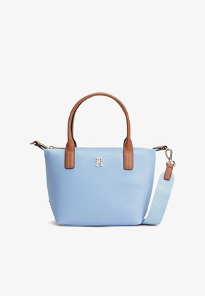 Sinine sünteetiline käekott pruunide nahast sangadega, hõbedase logoga, eemaldatava õlarihmaga ja tekstuurse pinnaga. Kompaktne, ruudukujuline.