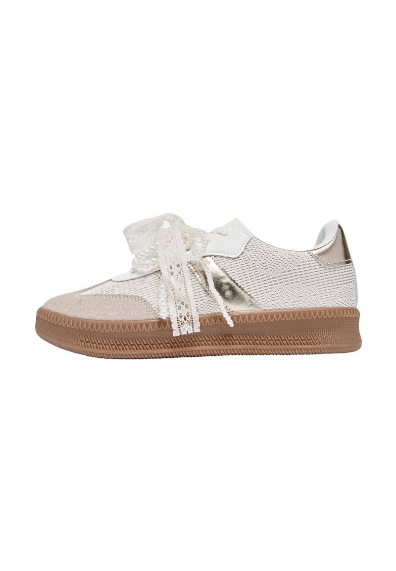 Baskets lacées avec une tige en mesh blanche et beige, ornées d'accents métalliques et d'une semelle en caoutchouc texturée. Détails décoratifs de lacets présents.
