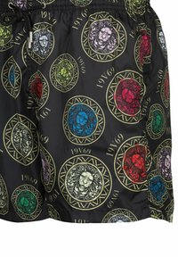 Zwarte zwemshorts met een meerkleurig leeuwenkoppatroon in gouden ronde frames, voorzien van een elastische tailleband en trekkoord.