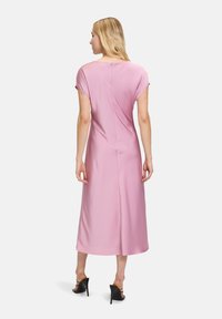Rosa Midi-Kleid mit kurzen Ärmeln, glattem Stoff, Reißverschluss hinten und figurbetonender Silhouette, die bis unter das Knie reicht.