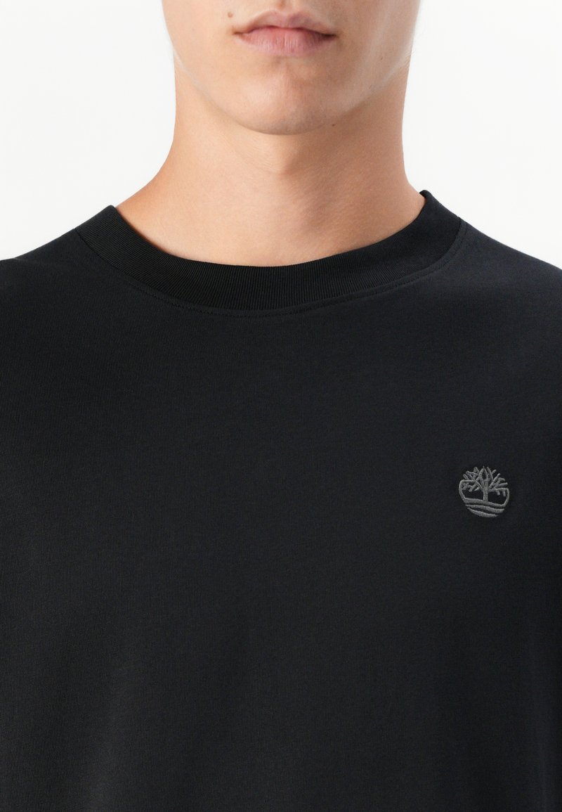 Czarny bawełniany T-shirt z okrągłym dekoltem, z małym, tonowym haftowanym logo na piersi. Gładka tekstura i dopasowany fason.