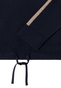 Granatowy sweter dziany z prążkowanym obszyciem na dole i mankietach. Posiada kontrastowy, beżowy pasek na rękawie oraz wiązanie na dole.