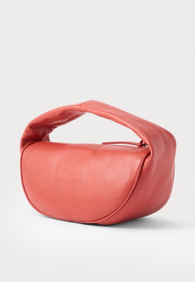 Τσάντα χειρός από απαλό ροζ δέρμα με στρογγυλή, επενδεδυμένη λαβή και κυρτό, δομημένο σώμα πάνω σε απλό φόντο.