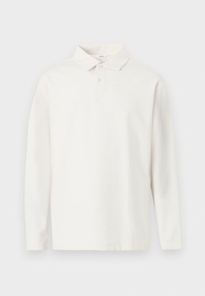 Hosszú ujjú fehér galléros póló két gombbal, egy világos háttéren laposan elhelyezve.