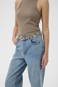 Brown ribbed tank top paired with high-waisted blue denim jeans. The outfit features a silver buckle belt with circular hardware details.
