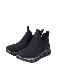 Chaussures noires à enfiler en matériau texturé, avec des panneaux élastiques sur les côtés et une semelle perforée pour la respirabilité.