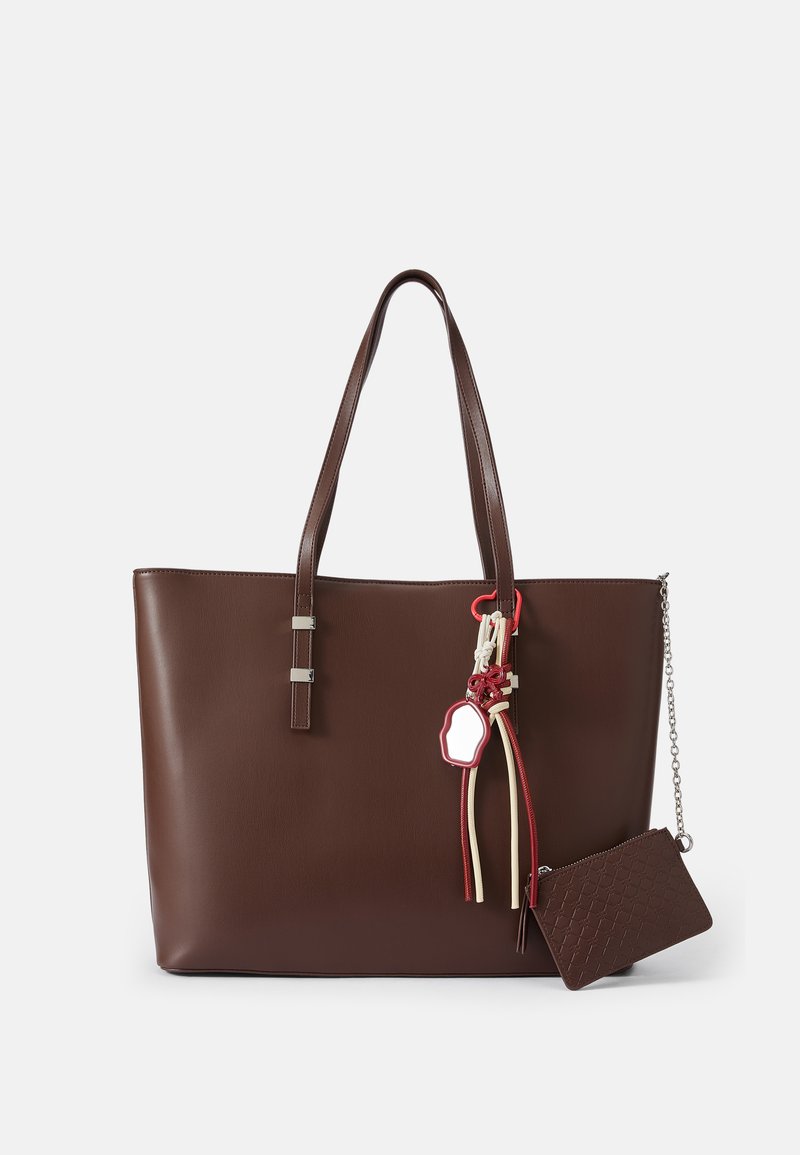 Bolso tote de cuero marrón con dos asas, detalles en hardware plateado, borlas decorativas y una pequeña cartera con cremallera a juego adjunta.