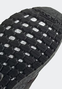 Suola di scarpa in gomma nera con un motivo di battistrada testurizzato, caratterizzata da porzioni rilavate e ritagli. Branding visibile di "Continental" sulla superficie.