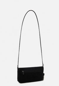 Sort ruskind crossbody taske med en tekstureret overflade, der har en lynlåslomme og en slank kædesti. Rektangulær form, minimalistisk design.