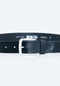 Cinturón de cuero negro con hebilla de metal plateado, que presenta una textura lisa y múltiples agujeros para su ajuste. El logo de la marca es visible.